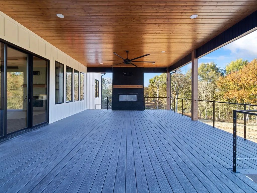 Covered outdoor deck with a stone fireplace